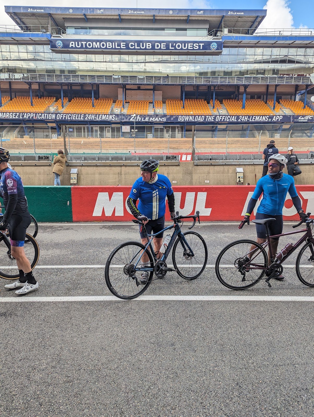 Cyclistes devant les tribunes du circuit Bugatti au Mans